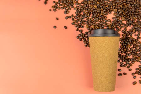 A mug of invigorating black coffee and coffee beans on a pink background. Place for an inscription. Concept of hot drinks and love.の写真素材