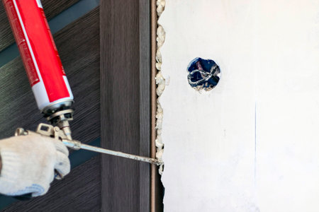 Installation of the door block. The worker fixes the door frame with foam.