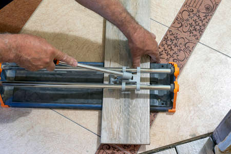 A worker uses a tile cutter to cut tiles to size.の写真素材