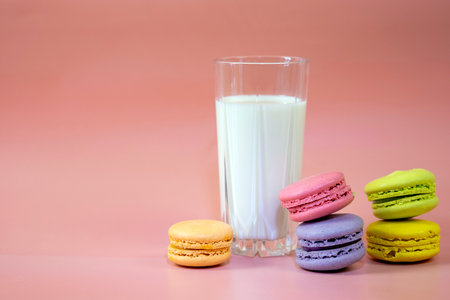 Close-up of a colorful macaroon or macaron with a glass of milk. Sweet and colorful french macaroons with copy space.の写真素材