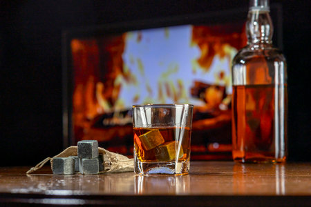 A glass of whiskey on a dark background. Whiskey cooling stones on the table.の写真素材
