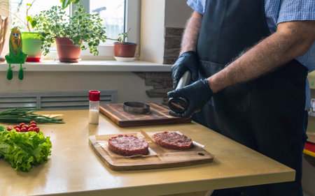 Chef making hamburger patties in the kitchen with ground beefの写真素材