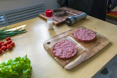 Cooking hamburger patties with ring mold in home kitchen.の写真素材