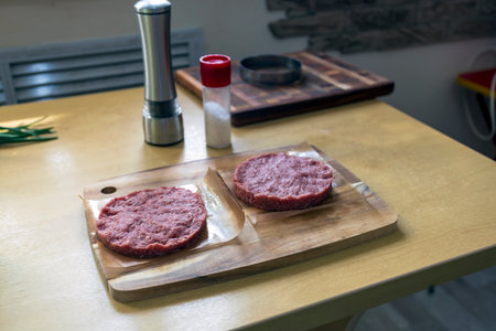 Cooking hamburger patties with ring mold in home kitchen.の写真素材