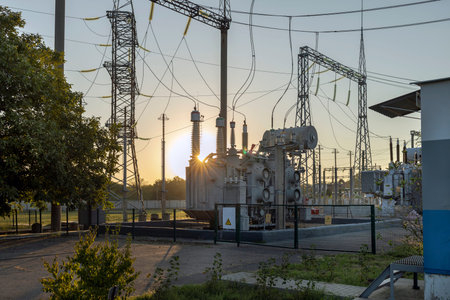 High voltage transformer and rays of the morning sun. Illumination from sunrise.