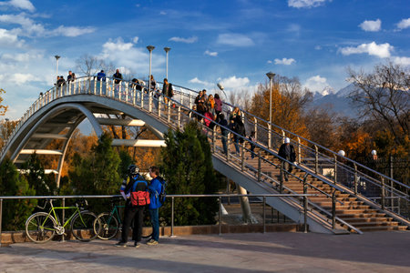 Almaty, Kazakhstan - October 27, 2014 arch bridge in the autumn park with mountain views. Park of the first president in Almaty - a favorite place of citizens at any time of the year. In summer it is hold festivals and holidaysのeditorial素材