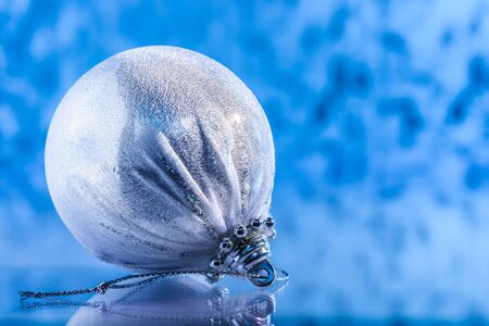 white Christmas ball on a blue winter background. Design of a New Year's backgroundの写真素材