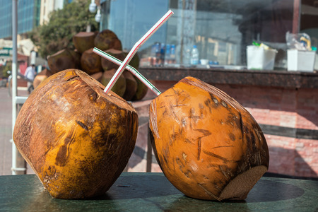 Coconut with a straw to drink on the table. refreshmentの写真素材