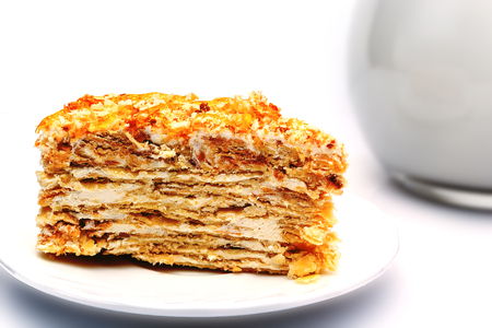 flaky pastry with cream on a plate next to a jug with milk. isolatedの写真素材