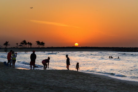 Dubai, UAE - January 7, 2017. Sunset on the beach. Silhouettes of people against the backdrop of the setting sun. Al Mamzar is one of Dubai's parks. The beach is clean and well-groomed, equipped with changing rooms, toilets and shower cabins. In the park のeditorial素材