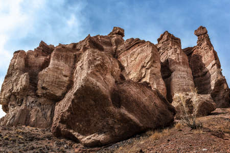 Dramatic rock porous sculpture on a background of a cloudy skyの写真素材