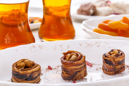 Oriental sweets dried melon with walnuts, dried apricots and tea in glass glasses.high key. Soft lightの写真素材