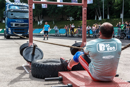 Almaty, Kazakhstan - May 28, 2017. strong man pulling heavy truck with a rope. City fesitwal sport on the street for a healthy lifestyle. Sports contests for arm-wrestling, heavy lifting, tug-of-war, army bench pressのeditorial素材
