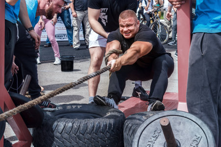 Almaty, Kazakhstan - May 28, 2017. Strong man pulls the rope. City fesitwal sport on the street for a healthy lifestyle. Sports contests for arm-wrestling, heavy lifting, tug-of-war, army bench pressのeditorial素材