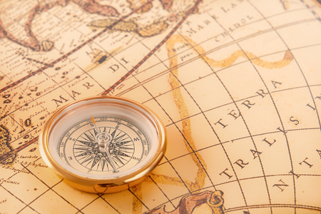 brass compass rests on an old vintage map. Copy space. Soft focusの写真素材