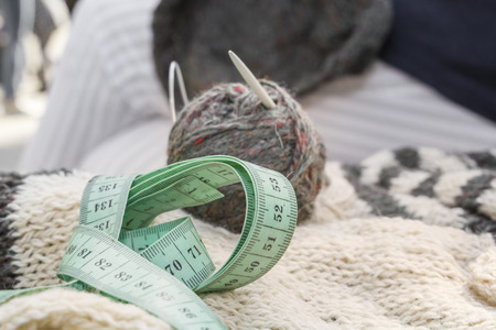 Wool coats, knitting needles, fabric meter and woolen clothes. close-upの写真素材