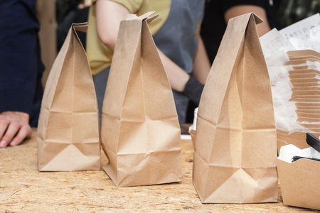 Three paper bags of coarse kraft paper are on the street counter. Close-up. Copy space