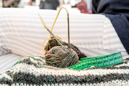 Wool coats, knitting needles, fabric meter and woolen clothes. close-up