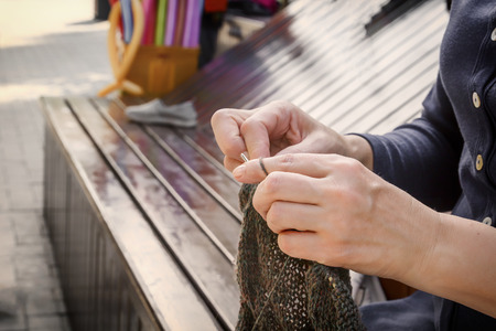 woman knits clothes from wool with knitting needles. Close-up. Copy space.の写真素材
