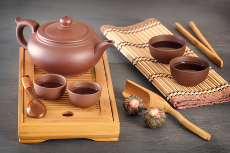 brown ceramic cups with a teapot on a special wooden tea tray prepared for a traditional Asian tea ceremonyの写真素材