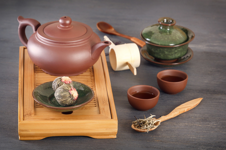 Green tea buds, ceramic teapot, cups, wooden tea tray and other attributes for a traditional tea ceremonyの写真素材