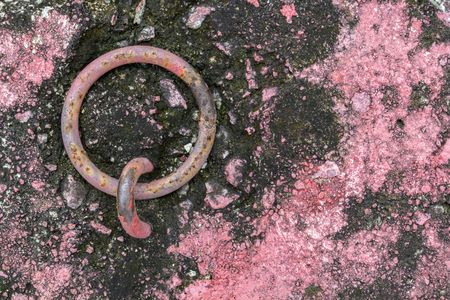 Rusty steel ring embedded in a concrete block with pink chips. Copy spaceの写真素材