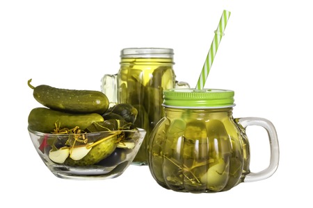 Cucumber pickle in a jar with a lid and a tube and pickled cucumbers in a plate isolated on white backgroundの写真素材