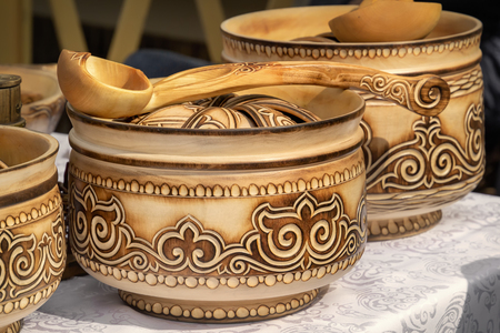 Traditional Kazakh wooden tableware with national ornament is sold on the street market.の写真素材