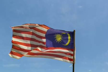 Flag of Malaysia fluttering in the wind against the blue sky with cloudsの写真素材