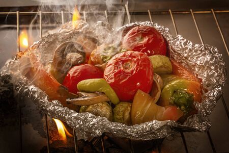 Vegetables in foil are baked on fire. Close-upの写真素材