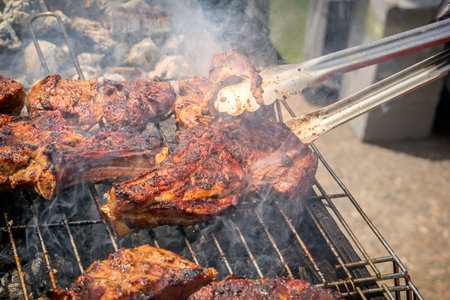 Cooking steak on the grill in the smoke on burning coals