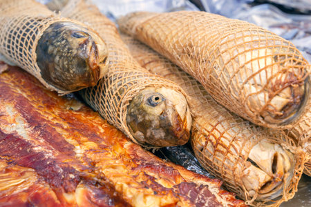 Smoked braided fish prepared for sale on a street tray. Close-up