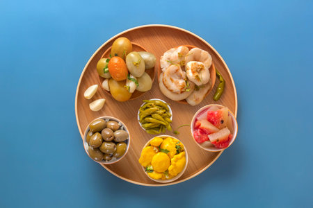Fermented products cabbage, peppers, pickles, tomatoes, mushrooms, zucchini, garlic on a blue table....