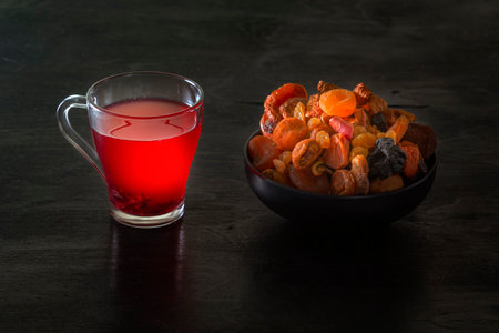 Drink from mix of dried fruits on a dark table. low key. Copy space