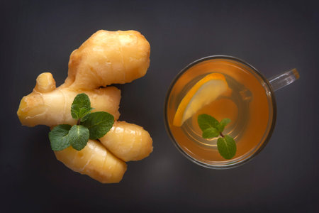 Tea with ginger and mint on a dark wooden table. Close-up. Top view