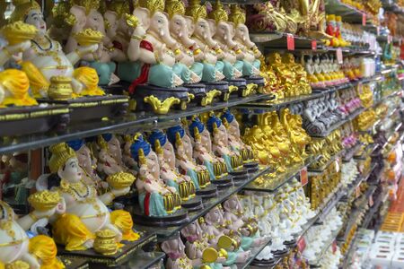Figurines of Hindu and Buddhist gods for sale on the shelves of a religious store in a templeの写真素材