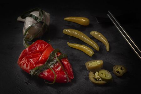 Fermented hot pepper and garlic on a dark wooden table. Low key.の写真素材