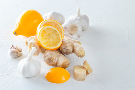 Ginger, garlic and lemon - a means to protect against viral infection and colds on a light wooden table. Copy spaceの写真素材
