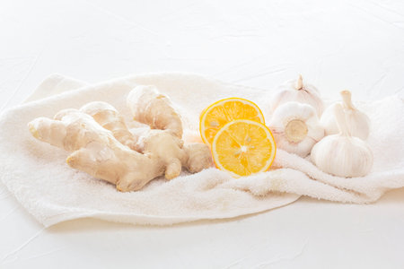 Ginger, garlic and lemon - a means to protect against viral infection and colds on a light wooden table. Copy spaceの写真素材