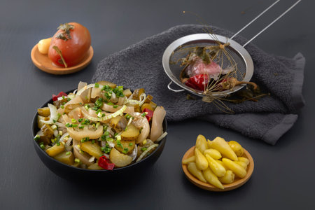 Fermented green tomatoes and cucumbers together with pickled garlic and peppers on a gray tableの写真素材