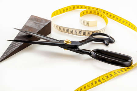 Opened scissors, tailor's tape measure, threads and pins on a white backgroundの写真素材