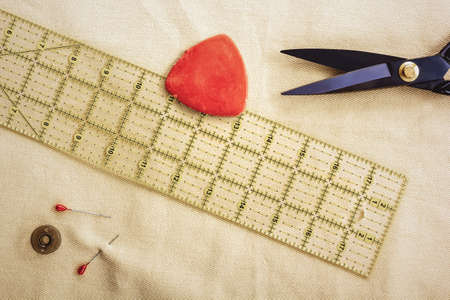Chalk, tailor's pattern, scissors and pins lie on a piece of fabric. View from aboveの写真素材