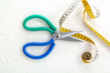 Opened scissors and tailor's tape measure on a white background. top viewの写真素材