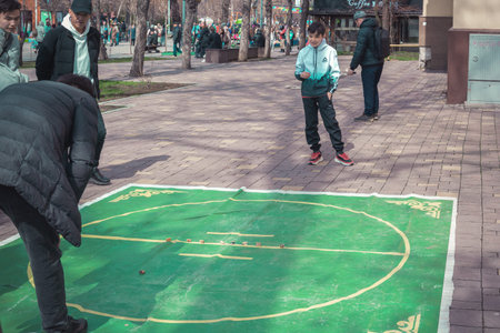 Almaty, Kazakhstan - March 21, 2022. Guys on the street play the game of the peoples of Central Asia asyk (sheep bone).のeditorial素材