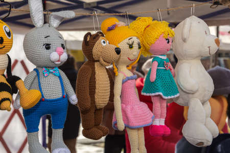 Colorful knitted handmade toys are on display for sale at a souvenir shopの写真素材