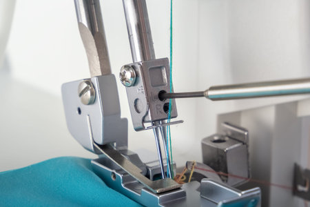 Repair and adjustment of a sewing machine or overlock with a screwdriver. close-up