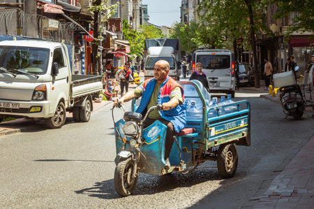 Istanbul, Turkey - April 29, 2022. Drinking water bottle carrier on a motor scooter on the streets...