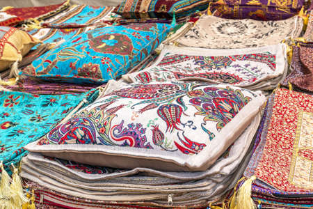 Pillows, pillowcases and handmade woven bedspreads in traditional Turkish style are sold at a street marketの写真素材