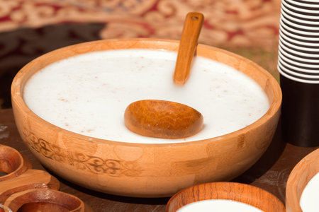 Traditional Asian wooden utensils with mare's milk koumiss or camel milk - shubat for sale in a street shopの写真素材