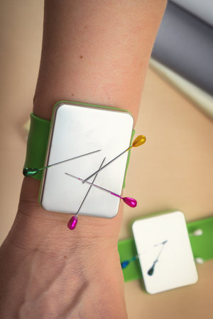 Bracelet with a magnet for needles and pins on the hand of a seamstress. close-up